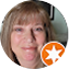 Headshot of a smiling man with light brown hair wearing a casual shirt with an orange star icon badge overlay